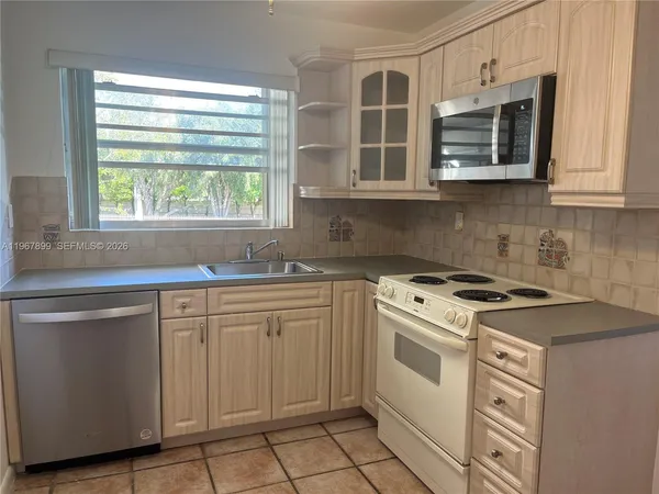 a kitchen with cabinets appliances and a window