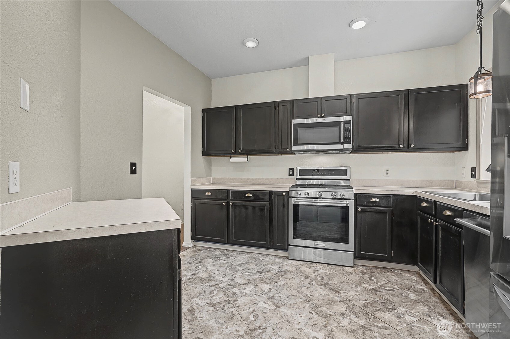 7239 Long Lake Road Southeast Port Orchard, WA 98367 - Photo 8 of 22 a kitchen with stainless steel appliances a stove sink microwave and cabinets