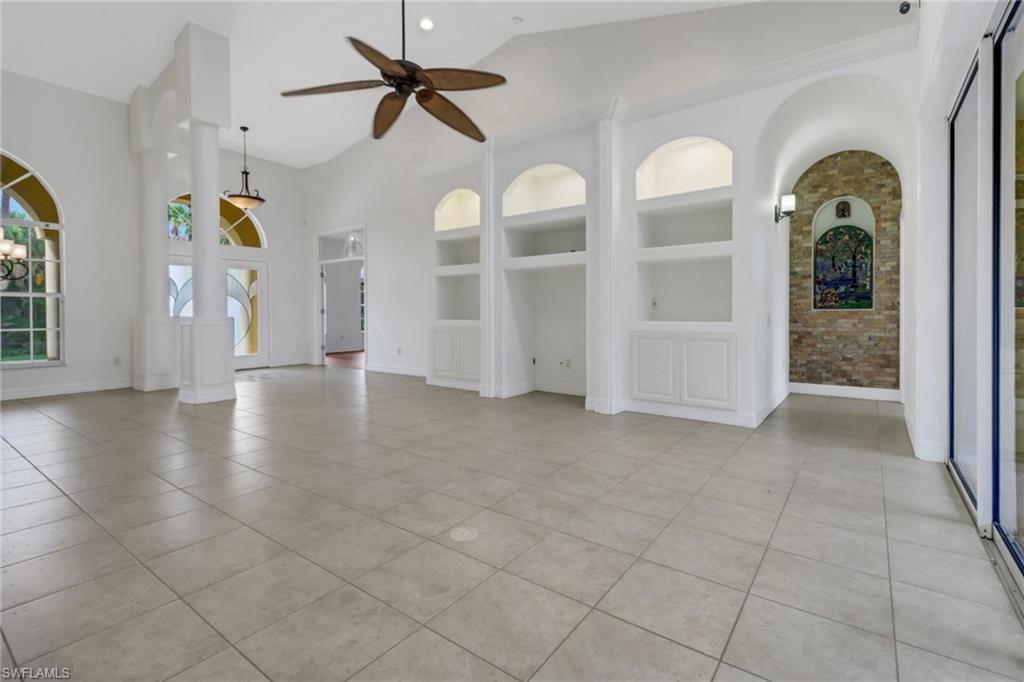 15480 River By Road Fort Myers, FL 33908 - Photo 12 of 48 Unfurnished living room with built in features, lofted ceiling, light tile patterned flooring, and ceiling fan
