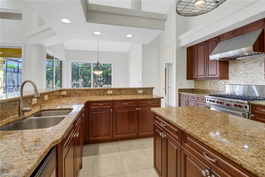 15480 River By Road Fort Myers, FL 33908 - Photo 15 of 48 Kitchen with wall chimney range hood, backsplash, light stone countertops, luxury range, and sink