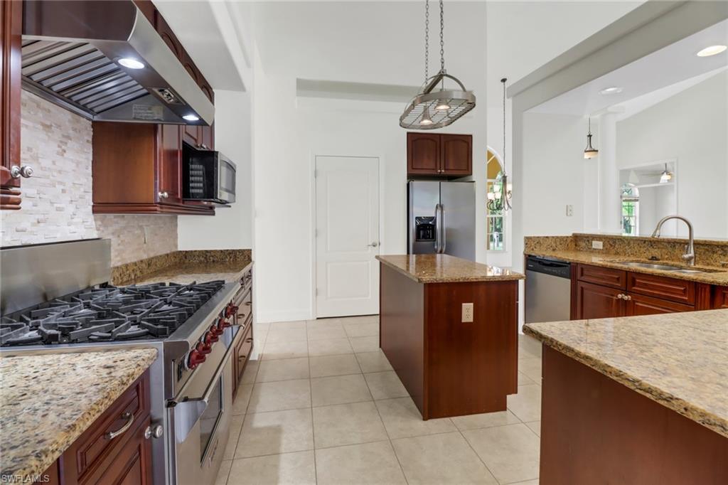 15480 River By Road Fort Myers, FL 33908 - Photo 17 of 48 Kitchen featuring stainless steel appliances, wall chimney exhaust hood, sink, light stone counters, and light tile patterned floors
