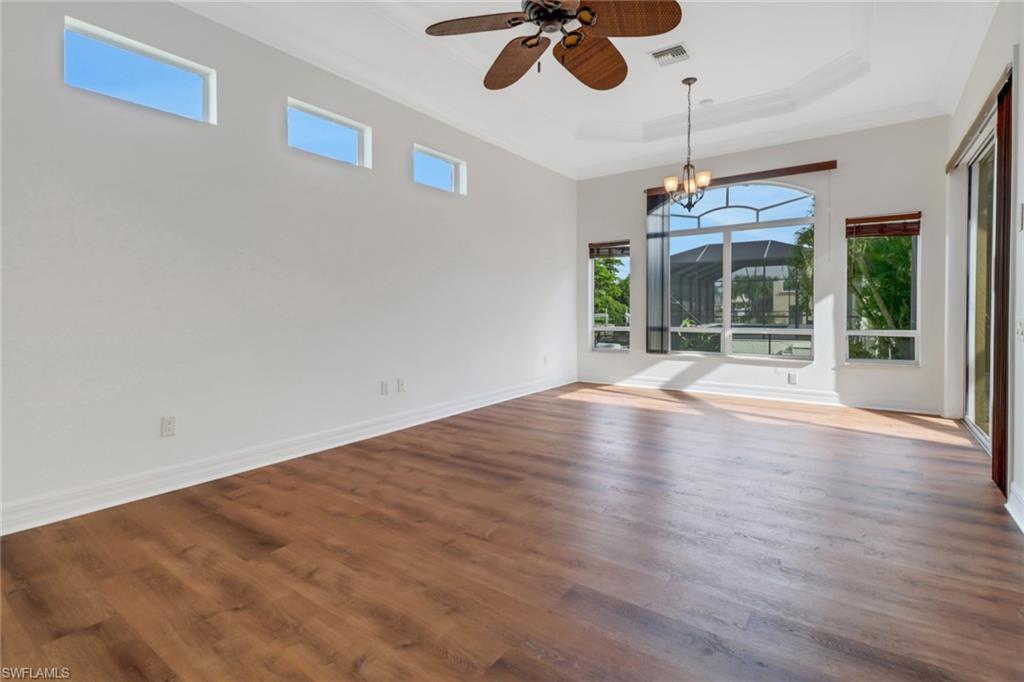 15480 River By Road Fort Myers, FL 33908 - Photo 21 of 48 Unfurnished room featuring hardwood / wood-style floors, ceiling fan with notable chandelier, and a tray ceiling