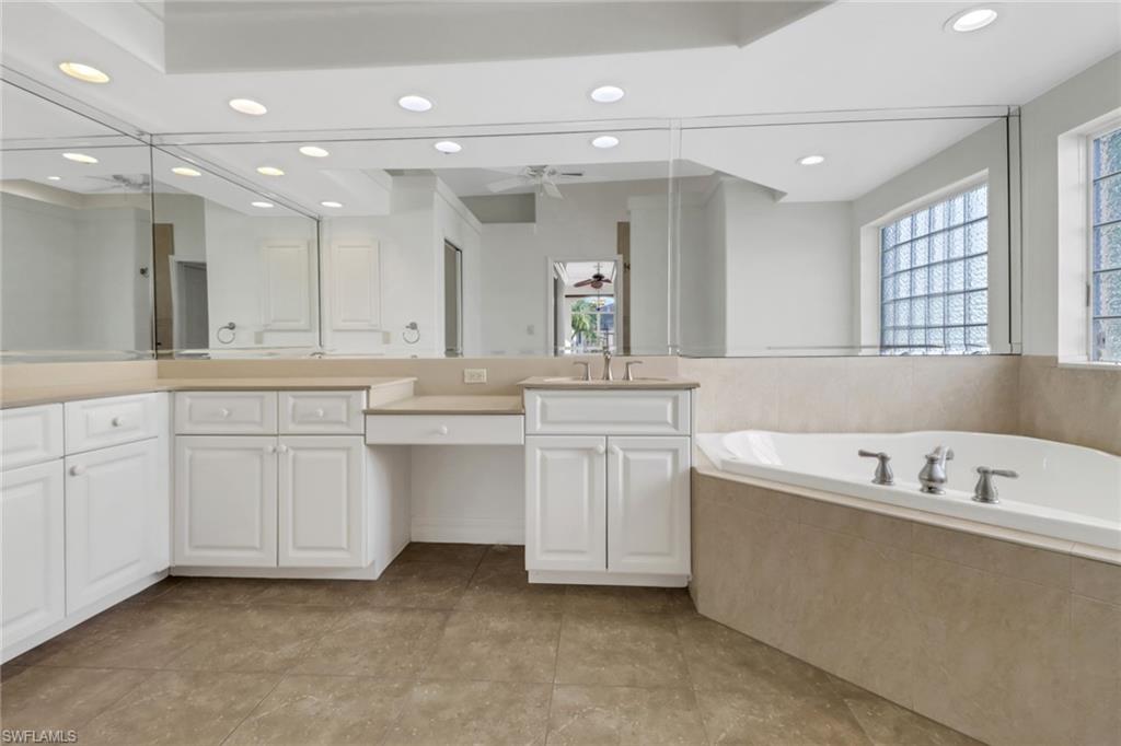 15480 River By Road Fort Myers, FL 33908 - Photo 23 of 48 Bathroom with ceiling fan, tiled bath, tile patterned flooring, and vanity