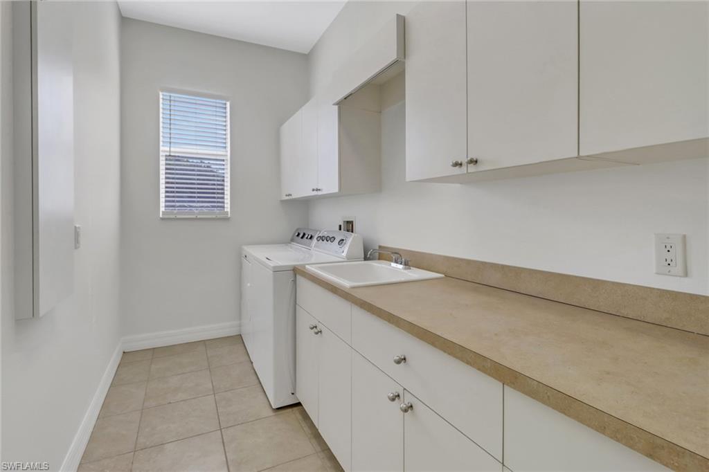 15480 River By Road Fort Myers, FL 33908 - Photo 29 of 48 Clothes washing area with sink, washing machine and clothes dryer, cabinets, and light tile patterned floors