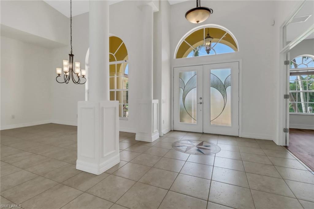 15480 River By Road Fort Myers, FL 33908 - Photo 8 of 48 Tiled entryway with a towering ceiling, an inviting chandelier, and french doors