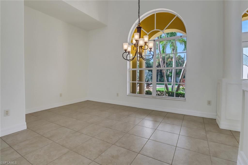 15480 River By Road Fort Myers, FL 33908 - Photo 9 of 48 Tiled empty room featuring a healthy amount of sunlight and a chandelier