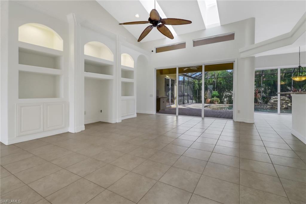15480 River By Road Fort Myers, FL 33908 - Photo 10 of 48 Unfurnished living room featuring ceiling fan, built in shelves, high vaulted ceiling, and light tile patterned flooring