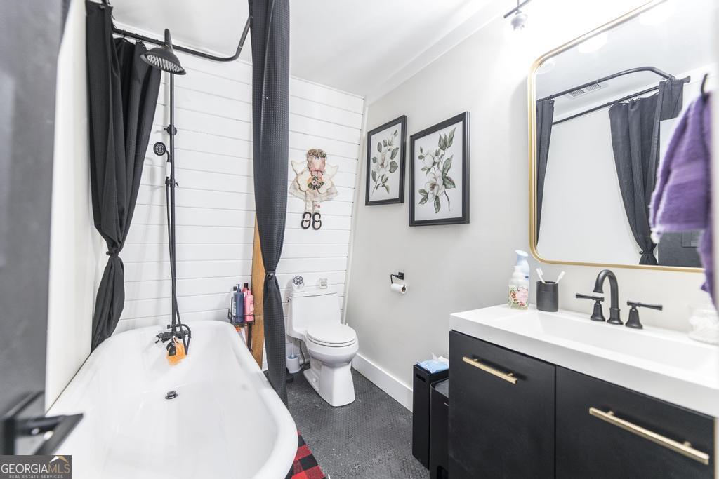 872 Henderson Road Dublin, GA 31021 - Photo 9 of 41 a bathroom with a sink vanity mirror bathtub and toilet