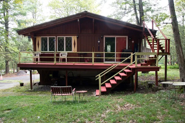 a view of a house with a yard chairs and iron fence