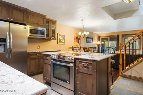 a kitchen with stainless steel appliances granite countertop a stove a refrigerator and a sink