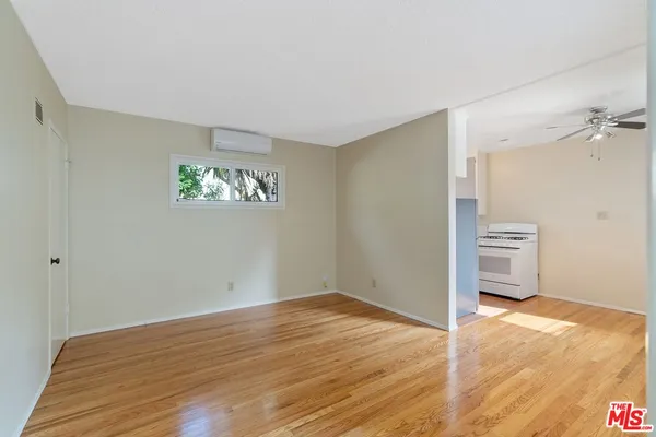 a view of empty room with wooden floor