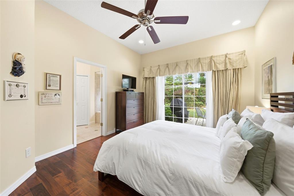 5452 Endicott Place Oviedo, FL 32765 - Photo 13 of 38 a large bed sitting in a bedroom next to a window and a chandelier