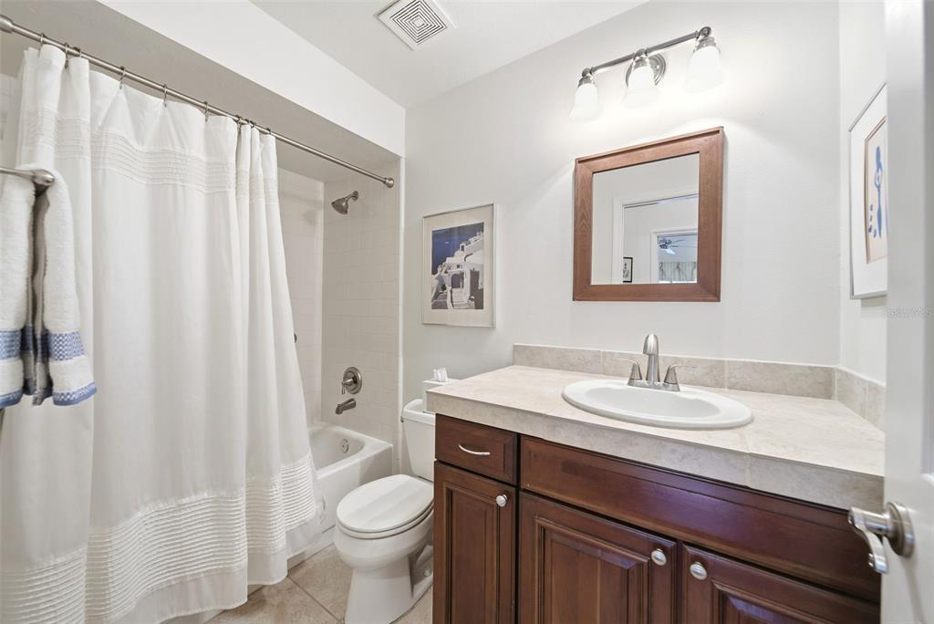 5452 Endicott Place Oviedo, FL 32765 - Photo 21 of 38 a bathroom with a granite countertop sink toilet and a mirror