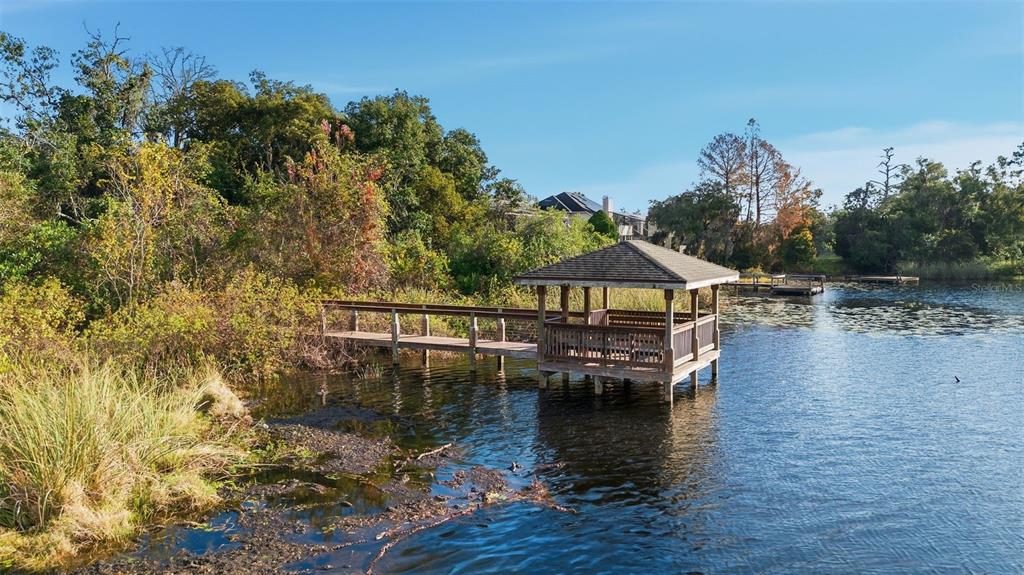 5452 Endicott Place Oviedo, FL 32765 - Photo 34 of 38 a view of a lake with roof and wooden fence