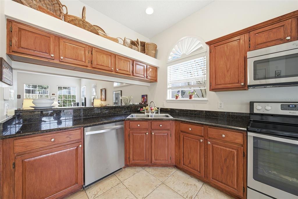 5452 Endicott Place Oviedo, FL 32765 - Photo 8 of 38 a kitchen with stainless steel appliances granite countertop a sink and cabinets