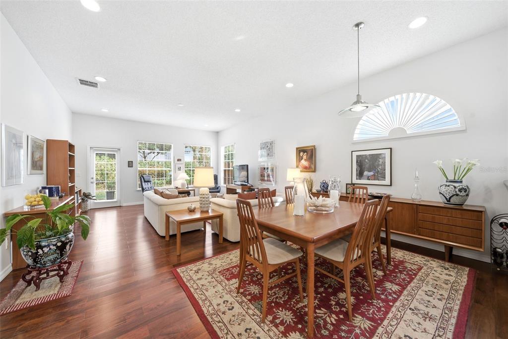 5452 Endicott Place Oviedo, FL 32765 - Photo 9 of 38 a view of a dining room and livingroom with furniture wooden floor a rug a rug a painting and a chandelier