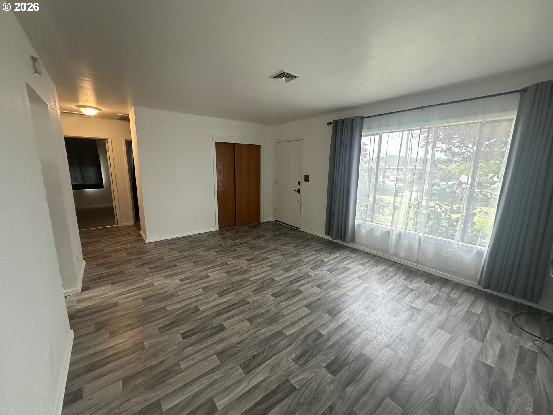 101 Southwest Peach Lane Winston, OR 97496 - Photo 7 of 22 a view of an empty room with wooden floor and a window