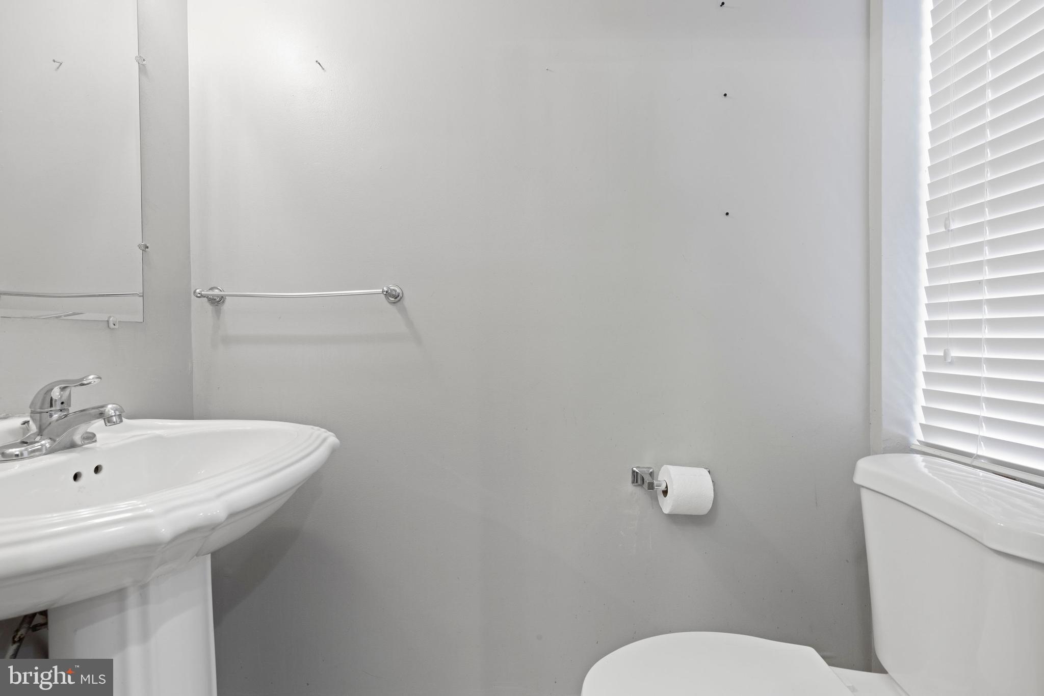 206 South Gilmor Street Baltimore, MD 21223 - Photo 12 of 27 a bathroom with a sink mirror and toilet