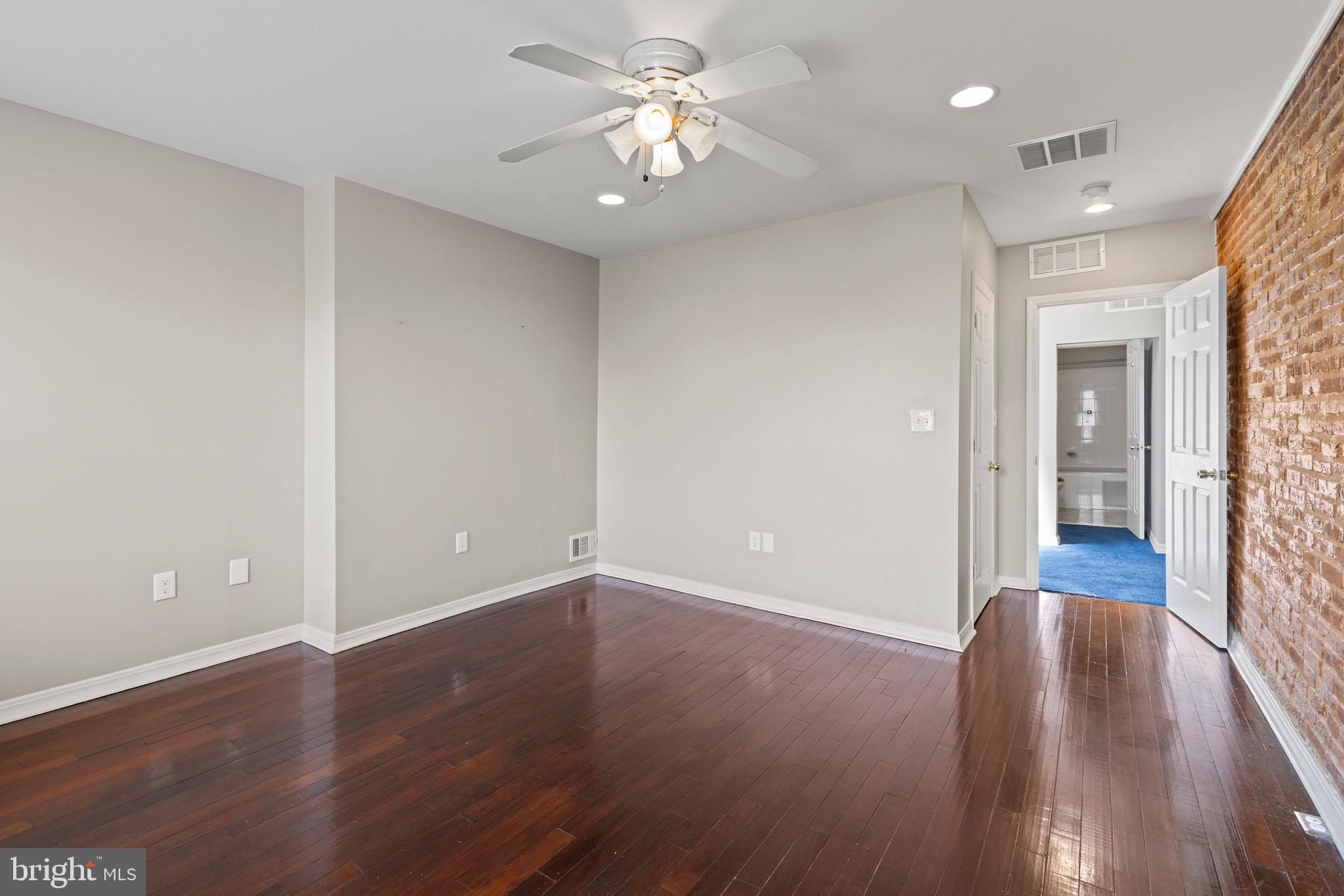 206 South Gilmor Street Baltimore, MD 21223 - Photo 21 of 27 an empty room with wooden floor and a ceiling fan