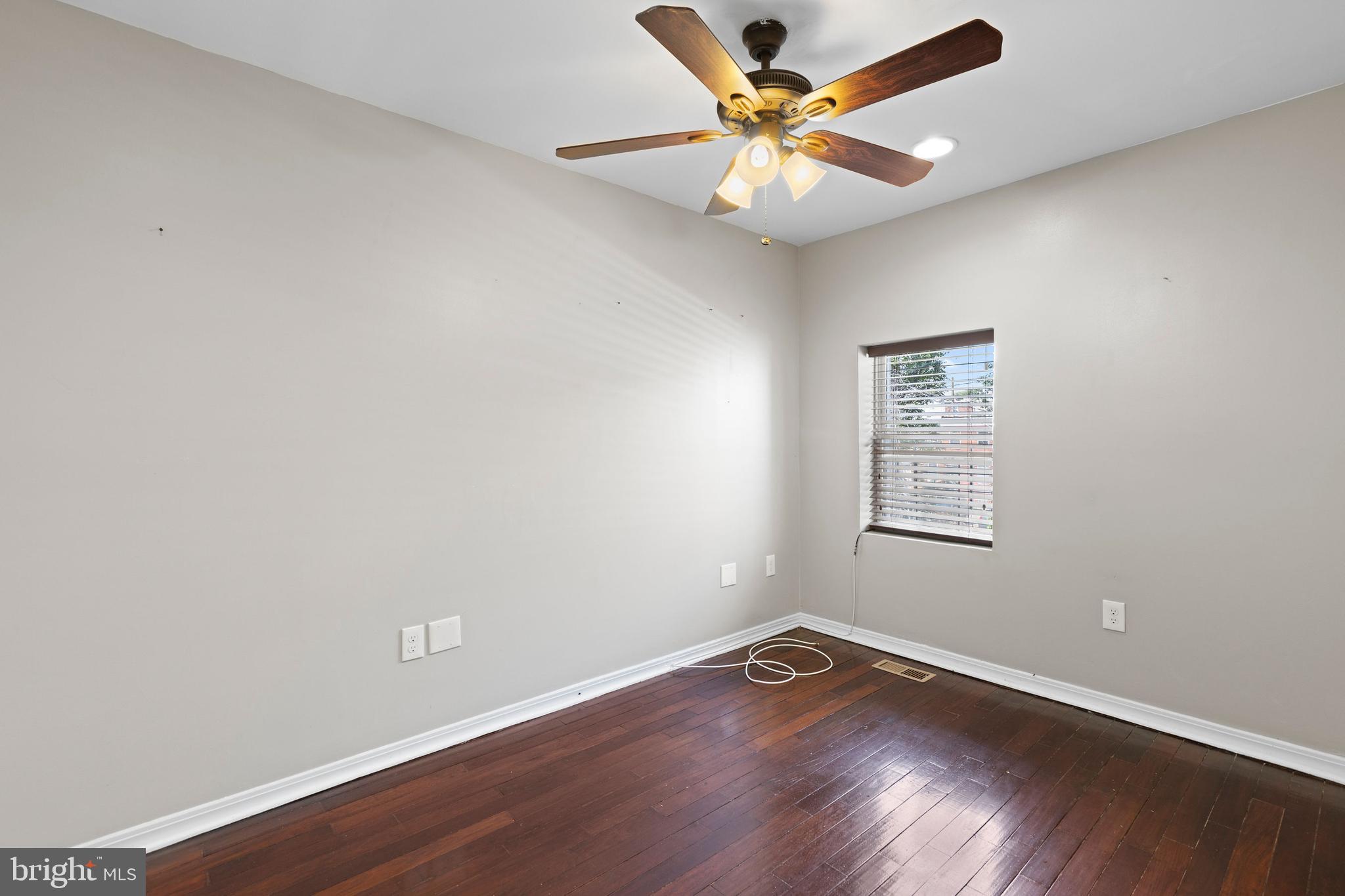206 South Gilmor Street Baltimore, MD 21223 - Photo 22 of 27 an empty room with wooden floor and a ceiling fan