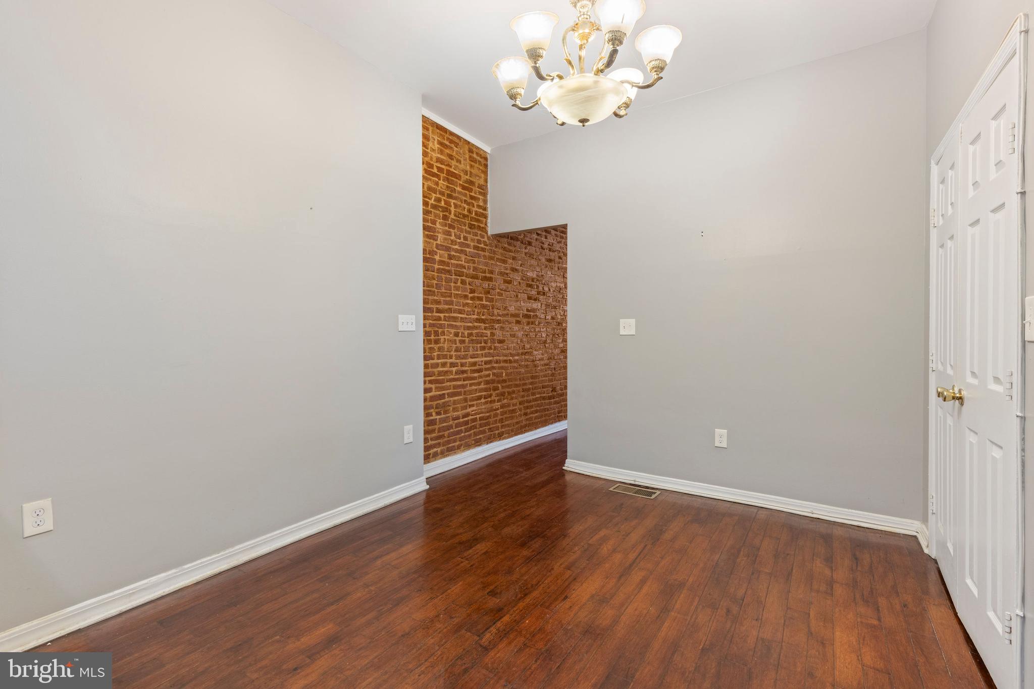 206 South Gilmor Street Baltimore, MD 21223 - Photo 8 of 27 an empty room with wooden floor