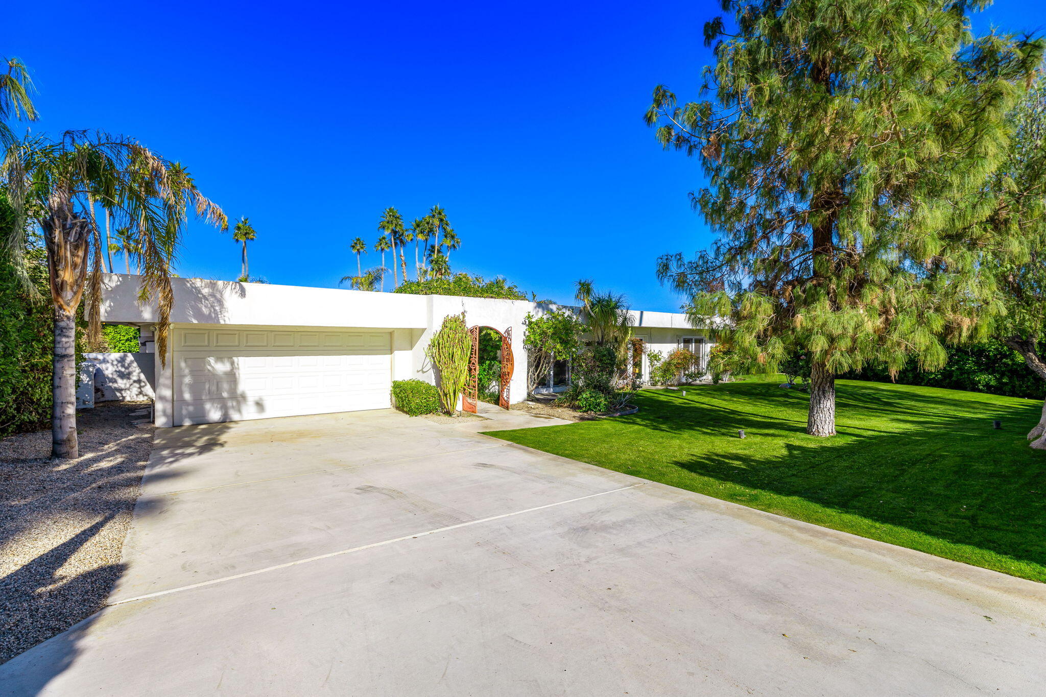 72890 Homestead Road Palm Desert, CA 92260 - Photo 7 of 45 a front view of a house with a yard and tree s