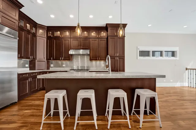 a kitchen with granite countertop a table chairs stainless steel appliances and cabinets