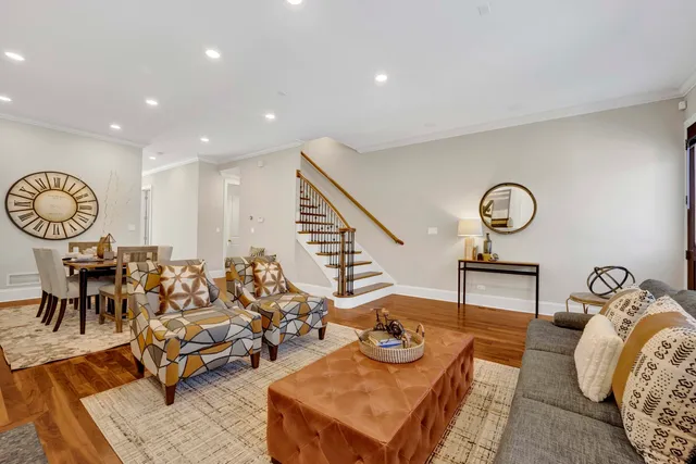 a living room with furniture kitchen view and a chandelier