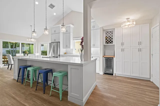 a open kitchen with stainless steel appliances granite countertop a refrigerator a oven and a wooden floors