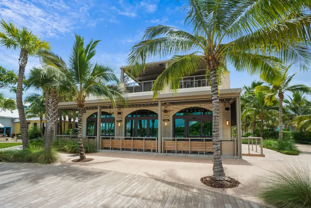 a front view of multi story residential apartment building with yard and green space