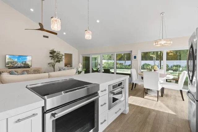 a kitchen with a stove and a view of living room
