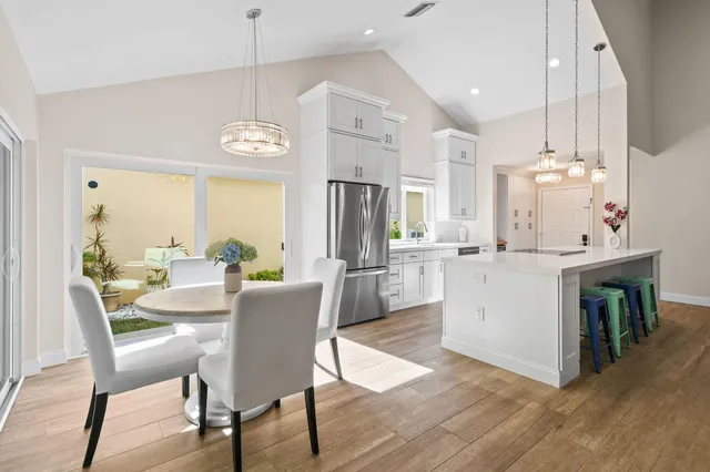 a view of kitchen with refrigerator stove dining table and chairs