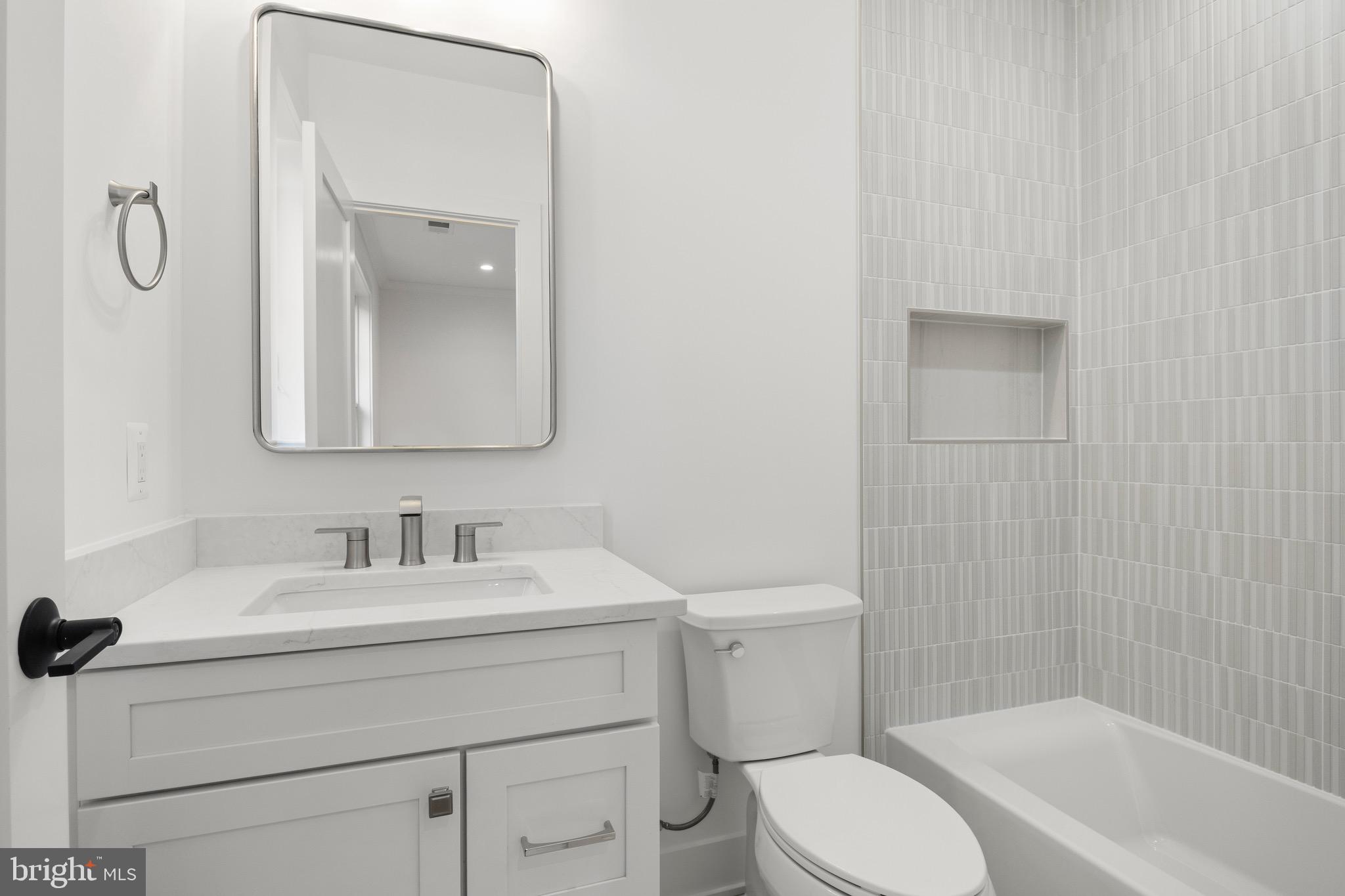 7804 Custer Road Bethesda, MD 20814 - Photo 45 of 68 a bathroom with a toilet sink vanity tub and mirror
