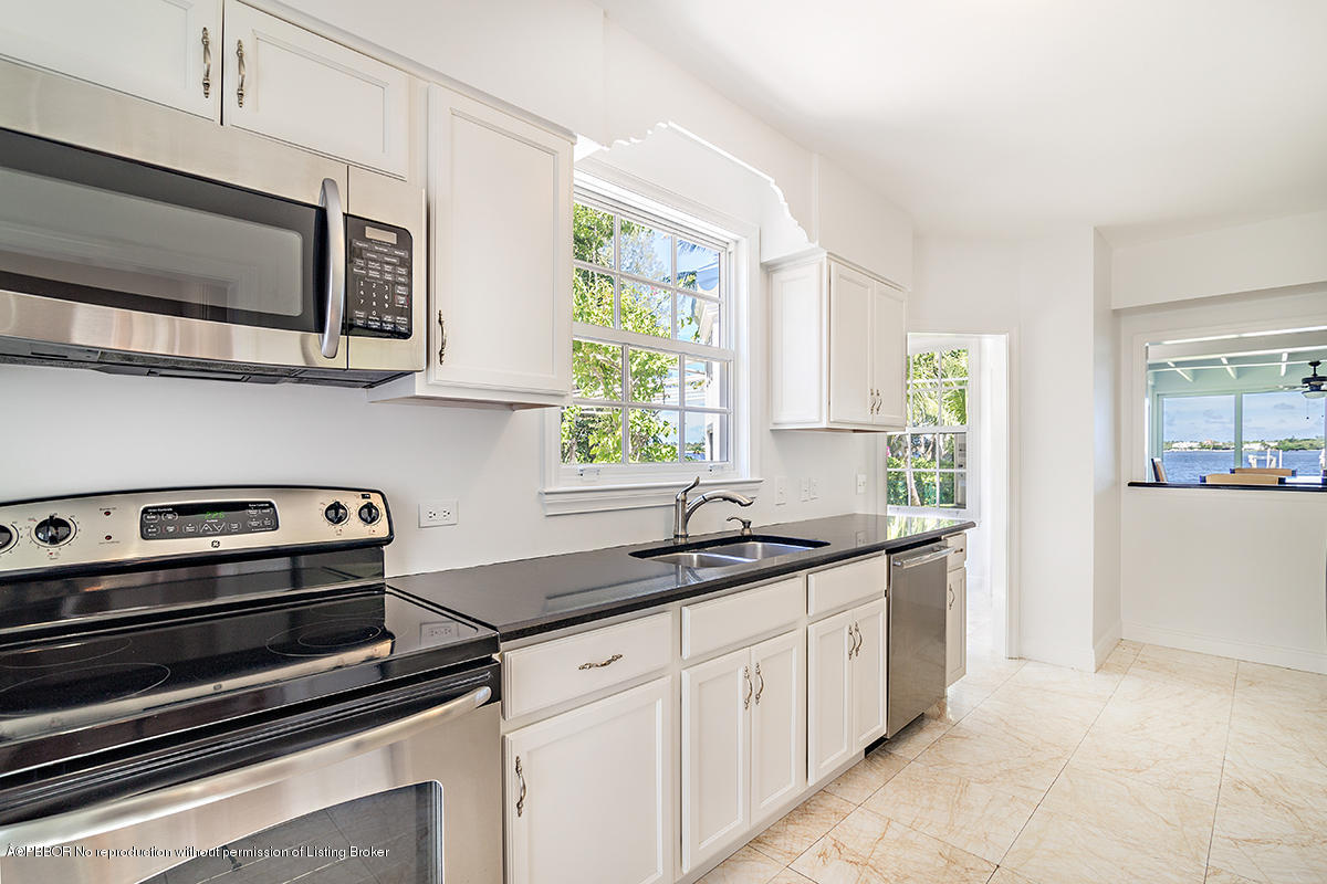 3130 Washington Road West Palm Beach, FL 33405 - Photo 10 of 33 a kitchen with stainless steel appliances a stove microwave and sink