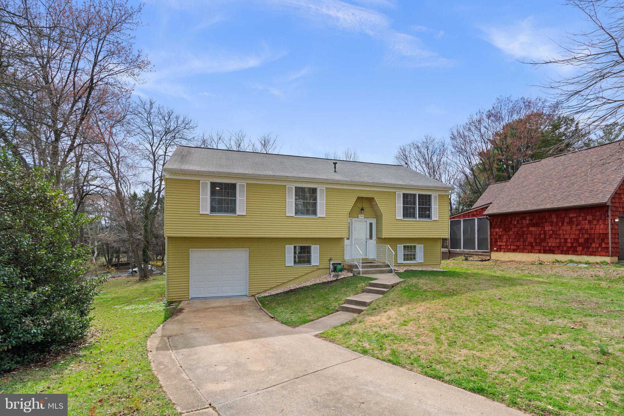 6968 Sunfleck Row Columbia, MD 21045 - Photo 3 of 45 a front view of a house with a yard and trees