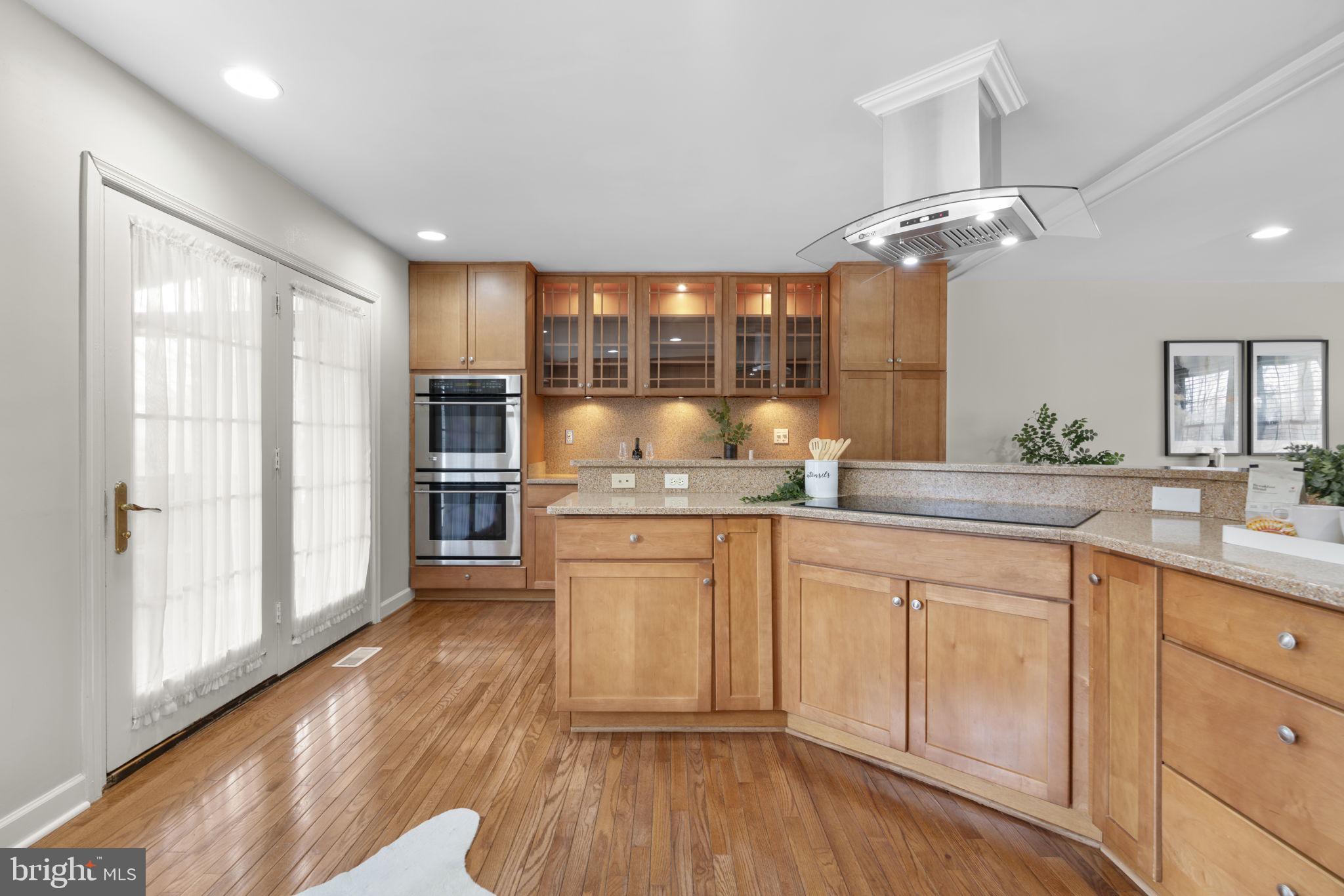 6968 Sunfleck Row Columbia, MD 21045 - Photo 5 of 45 a kitchen with granite countertop white cabinets and stainless steel appliances