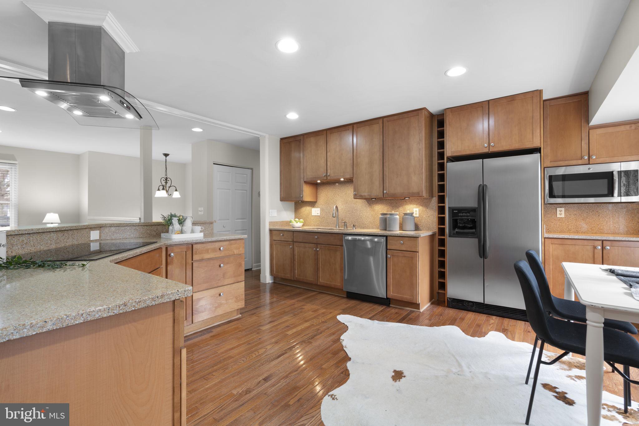 6968 Sunfleck Row Columbia, MD 21045 - Photo 6 of 45 a kitchen with stainless steel appliances granite countertop a sink refrigerator and cabinets