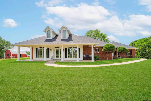 a front view of a house with a garden and trees