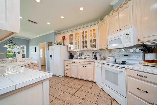 a kitchen with white cabinets and white appliances