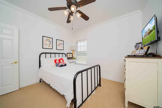 a bedroom with a bed and a flat tv screen on dresser