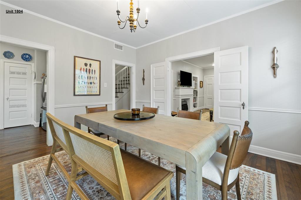 1806 Pearl Street Austin, TX 78701 - Photo 11 of 19 Dining area featuring wood-finish flooring, a traditional chandelier, picture frame molding, and a wide cased opening with pocket doors