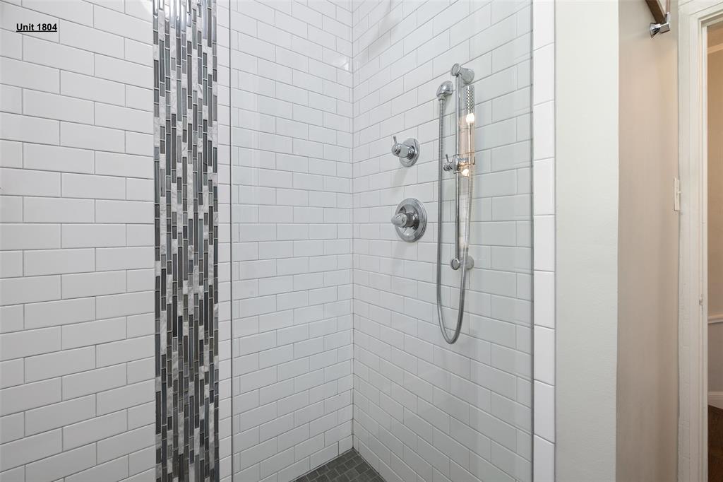 1806 Pearl Street Austin, TX 78701 - Photo 12 of 19 Shower enclosure featuring white subway tile, a vertical mosaic tile accent strip, and a handheld shower system with polished chrome fixtures