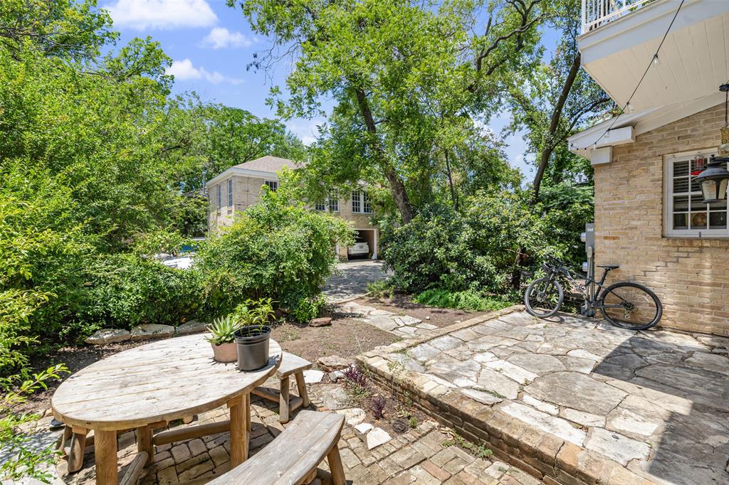 1806 Pearl Street Austin, TX 78701 - Photo 19 of 19 Exterior patio featuring flagstone paving, brick retaining wall, and mature trees