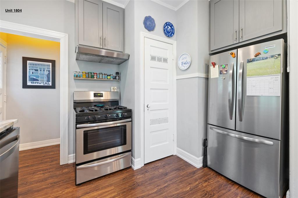 1806 Pearl Street Austin, TX 78701 - Photo 4 of 19 Kitchen featuring wood-finish flooring, stainless steel appliances, grey cabinetry, and white baseboard trim