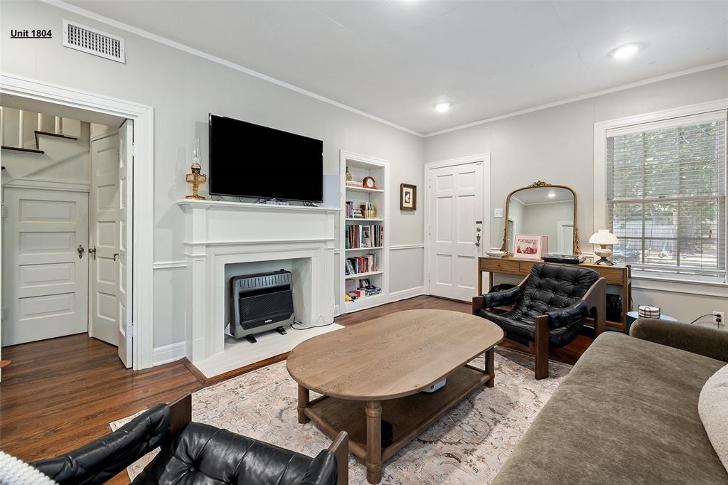 1806 Pearl Street Austin, TX 78701 - Photo 6 of 19 Living area featuring a white mantelpiece, built-in shelving, wood-finish flooring, recessed lighting, and a paneled door