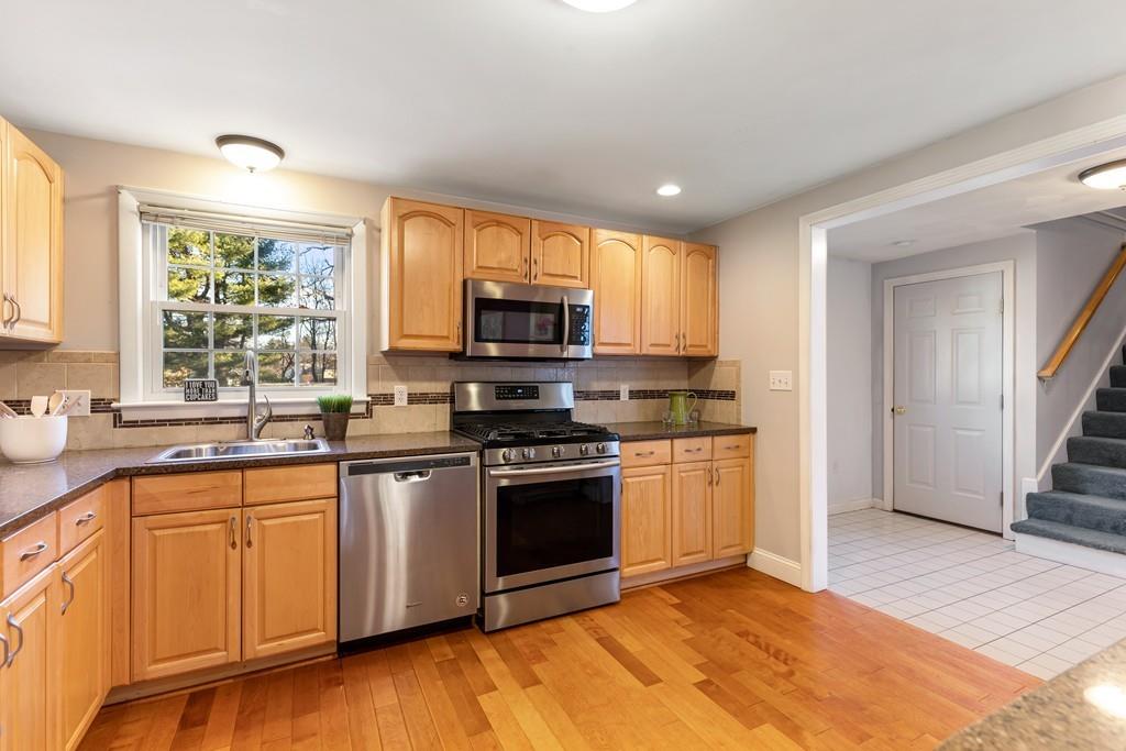 294 Salem Road Billerica, MA 01821 - Photo 4 of 25 a kitchen with stainless steel appliances granite countertop a stove top oven a sink dishwasher a refrigerator and a microwave