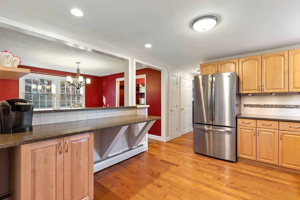 294 Salem Road Billerica, MA 01821 - Photo 6 of 25 a kitchen with stainless steel appliances granite countertop a refrigerator a stove and a sink with wooden floors