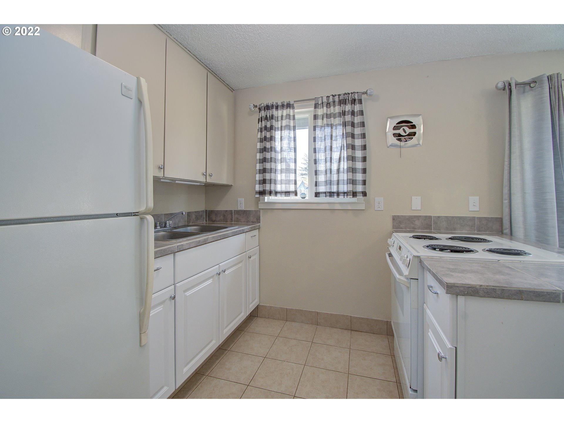 2912 R Street Vancouver, WA 98663 - Photo 11 of 24 a kitchen with a stove cabinets and a window