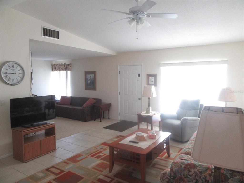 8158 Fay Avenue North Port, FL 34287 - Photo 3 of 23 a living room with furniture a clock on wall and a window