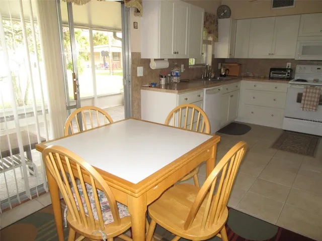 a kitchen with a table chairs sink and cabinets